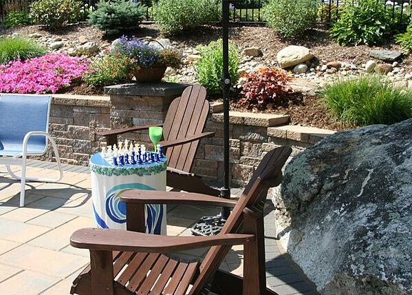 Outdoor seating area surrounded by lush landscaping