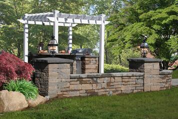 Outdoor Kitchen with Built-in Grill and Pergola by Bahler Brothers in CT