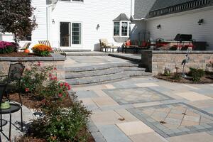 Paver Paver Patio with Retaining Walls and Outdoor Kitchen